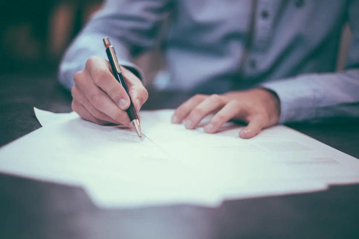 Pessoa analisando contrato bancário e documentos financeiros